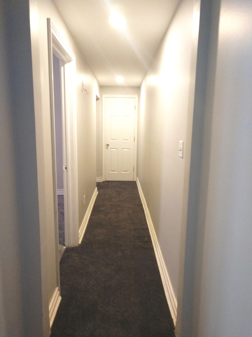 853 Adams Street, Unit 1 Waukegan, IL 60085 - Photo 7 of 9 a view of a hallway with a white walls