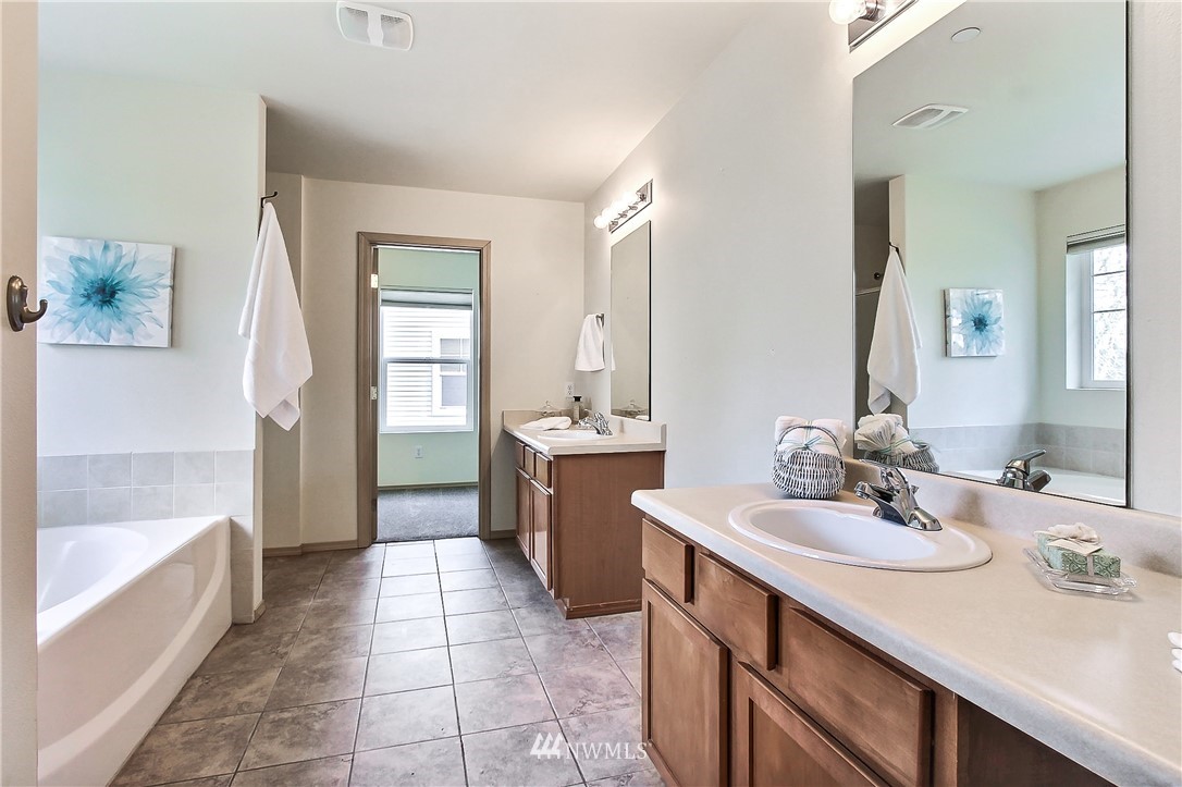3141 Walker Road DuPont, WA 98327 - Photo 17 of 18 a bathroom with a sink a tub and a mirror