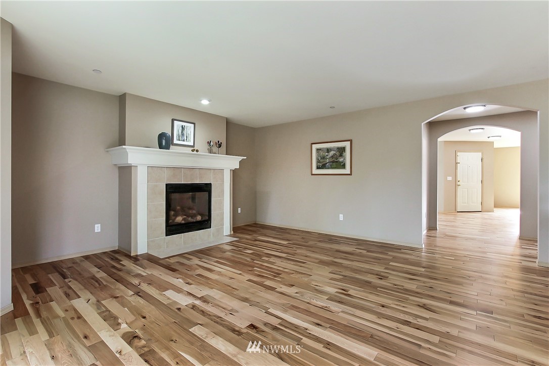 3141 Walker Road DuPont, WA 98327 - Photo 7 of 18 a view of an empty room with wooden floor and a fireplace