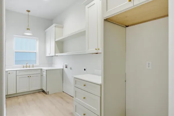 a kitchen with white cabinets and sink