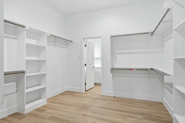 a view of walk in closet with empty racks