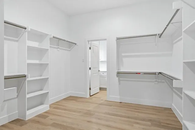 a view of walk in closet with empty racks
