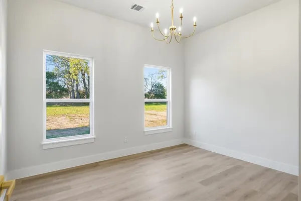 an empty room with a window and wooden floor