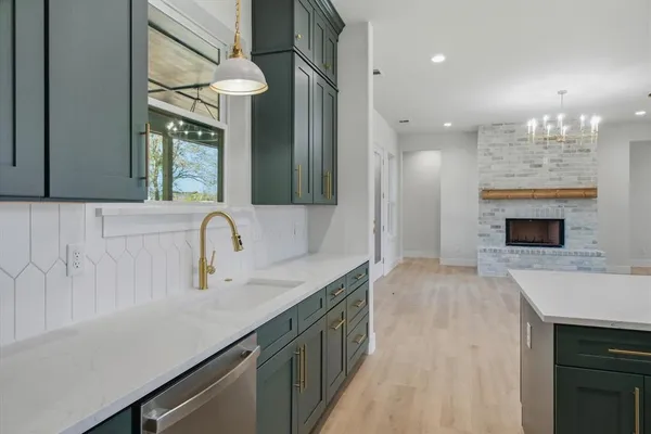 a kitchen with a sink dishwasher a stove and a refrigerator with wooden floor