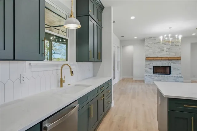 a kitchen with a sink dishwasher a stove and a refrigerator with wooden floor