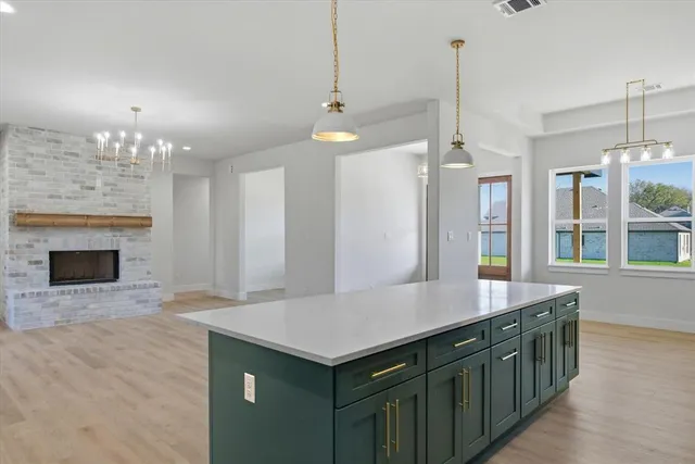 a kitchen with kitchen island a sink stainless steel appliances and a chandelier