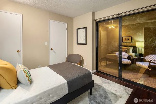 a bedroom with a large bed and glass door