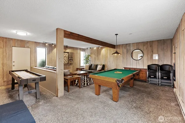 a room with furniture pool table and wooden floor