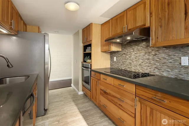 a kitchen with stainless steel appliances granite countertop a refrigerator and a sink