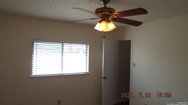 a view of a chandelier fan and a window