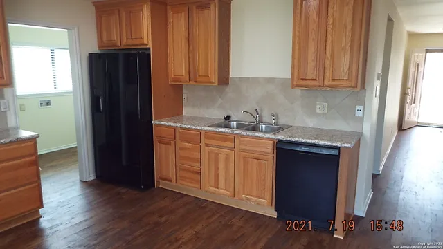 a kitchen with granite countertop wooden cabinets and a sink
