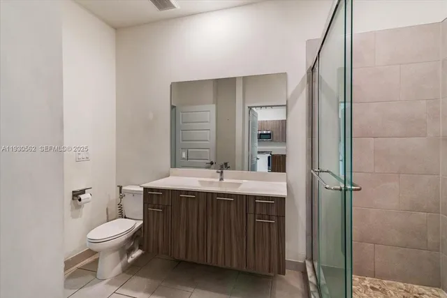 a bathroom with a granite countertop toilet a sink and a mirror