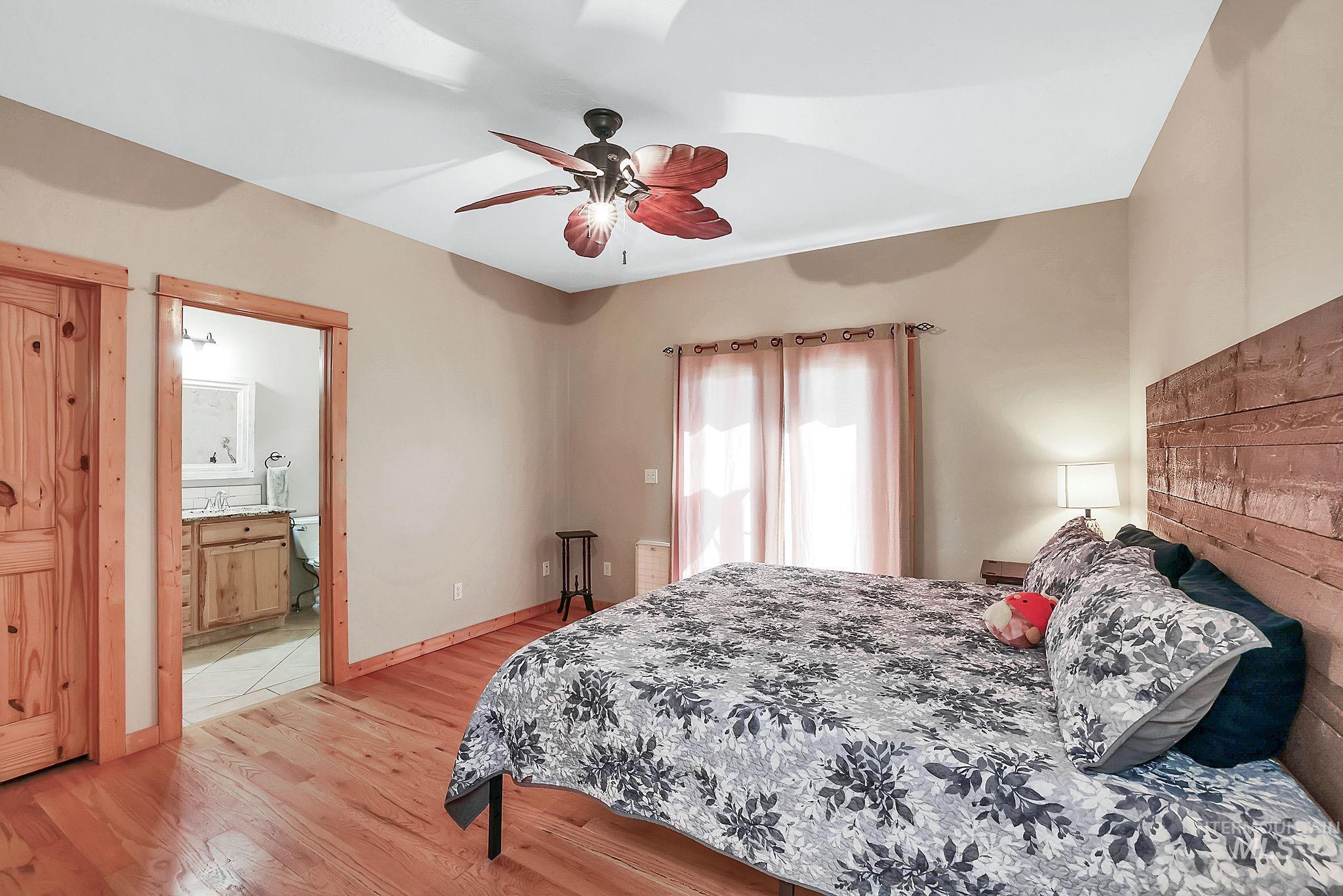12954 Upland Road Donnelly, ID 83615 - Photo 14 of 41 Bedroom featuring light wood-style floors, ceiling fan, and ensuite bathroom