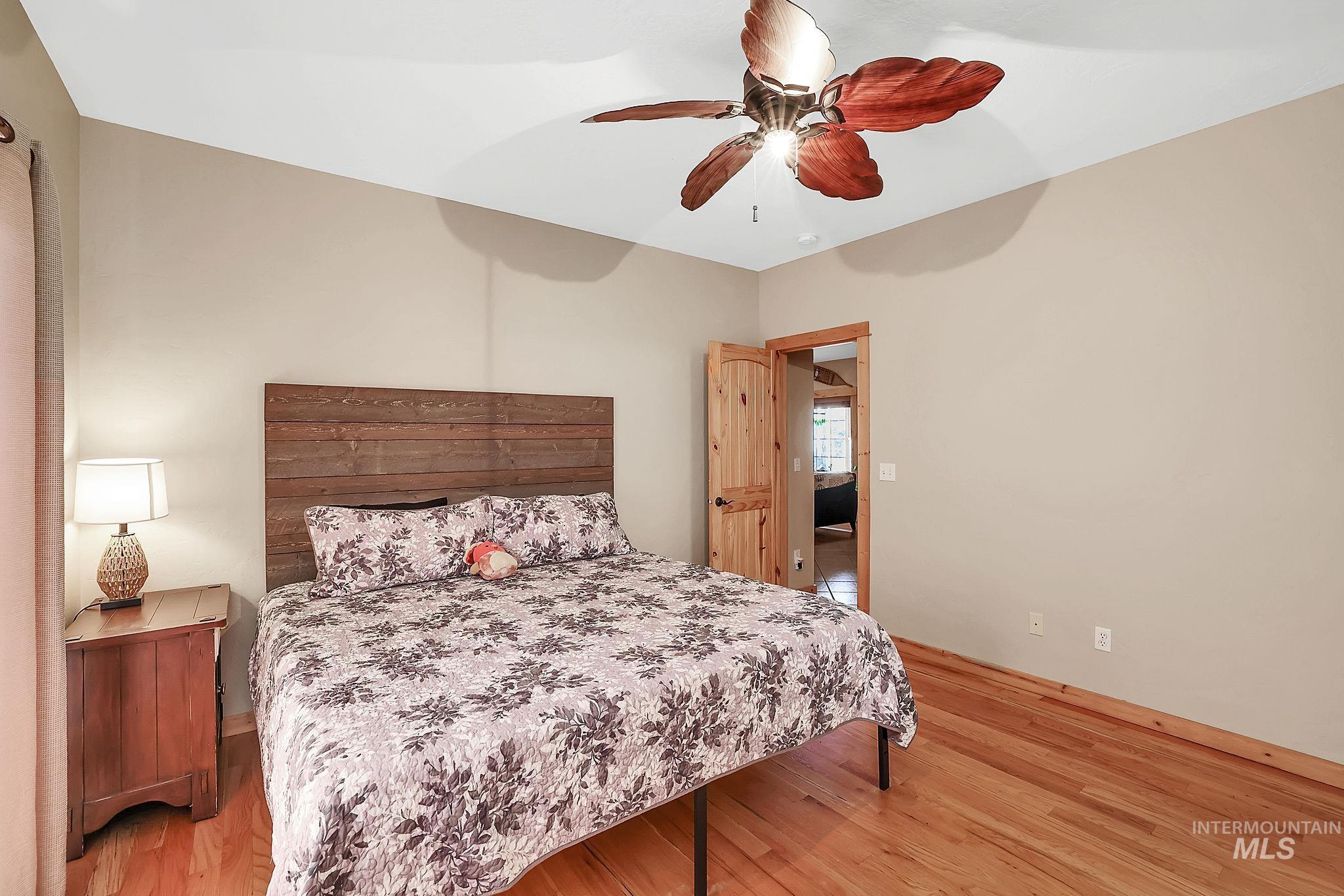 12954 Upland Road Donnelly, ID 83615 - Photo 16 of 41 Bedroom with light wood-style floors and ceiling fan