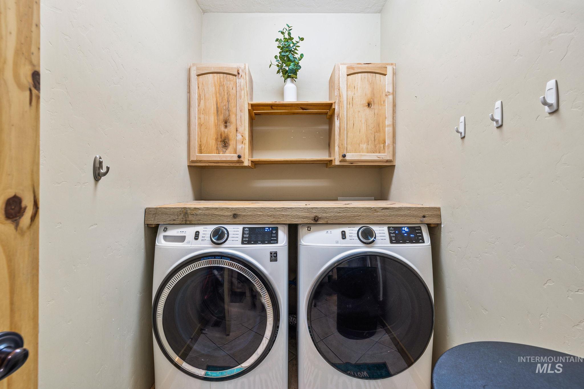 12954 Upland Road Donnelly, ID 83615 - Photo 28 of 41 Laundry room featuring washer and dryer, a textured wall, and cabinet space