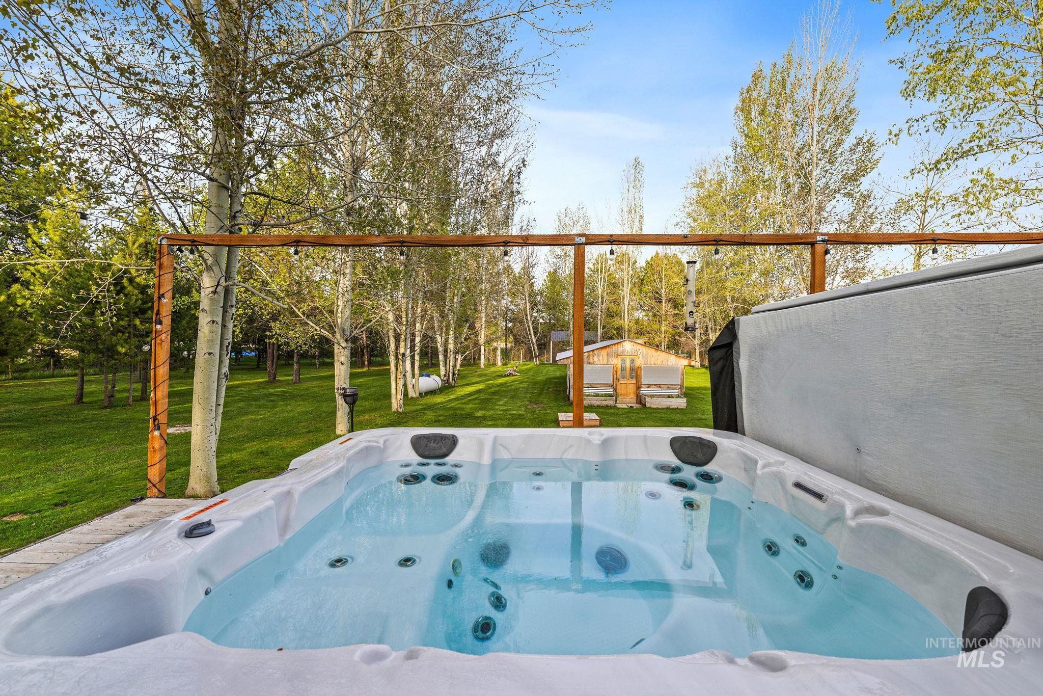 12954 Upland Road Donnelly, ID 83615 - Photo 31 of 41 View of patio / terrace featuring a hot tub and an outdoor structure