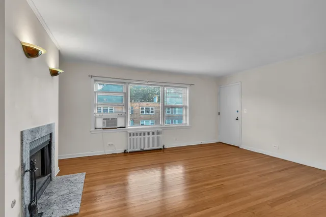 wooden floor fireplace and windows in an empty room