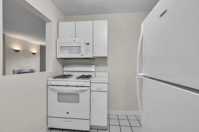 a kitchen with white cabinets and white appliances