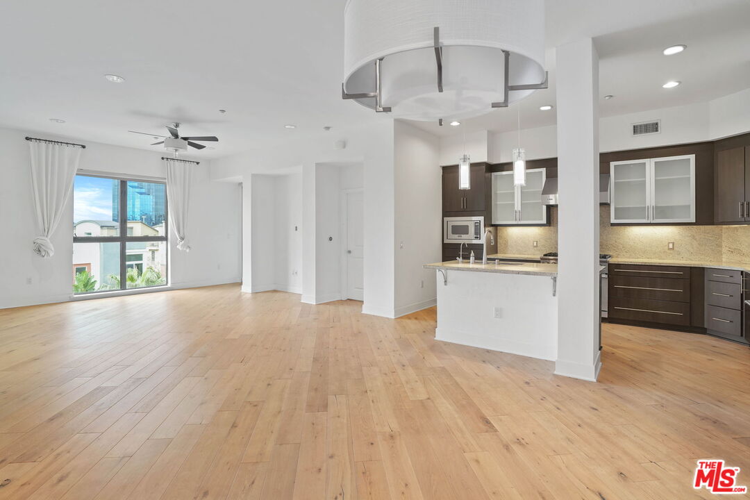 402 Rockefeller, Unit 406 Irvine, CA 92612 - Photo 12 of 33 a view of a kitchen with a sink and dishwasher a refrigerator with wooden floor