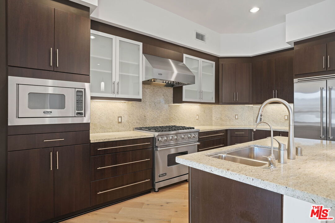 402 Rockefeller, Unit 406 Irvine, CA 92612 - Photo 7 of 33 a kitchen with stainless steel appliances granite countertop a sink stove and cabinets
