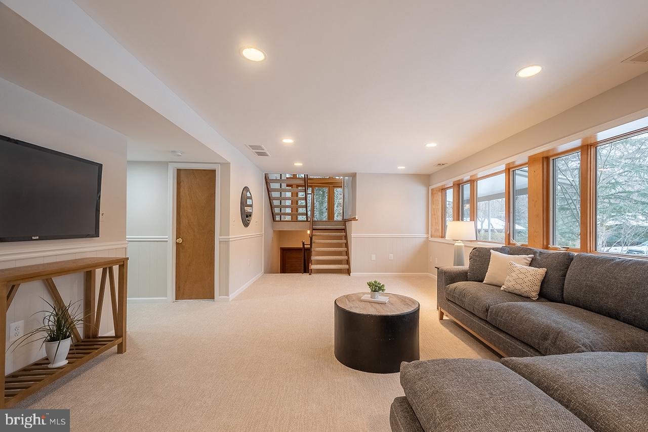 2529 Trophy Lane Reston, VA 20191 - Photo 41 of 69 a living room with furniture a flat screen tv and a floor to ceiling window