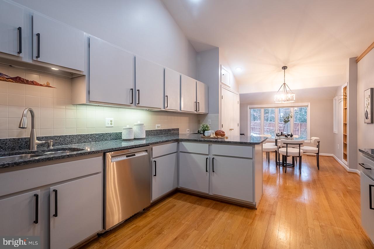 2529 Trophy Lane Reston, VA 20191 - Photo 8 of 69 a kitchen with granite countertop white cabinets a sink dishwasher and a stove with wooden floor