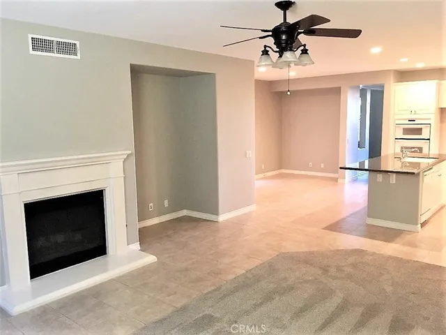 a view of a livingroom with a fireplace a chandelier and stairs