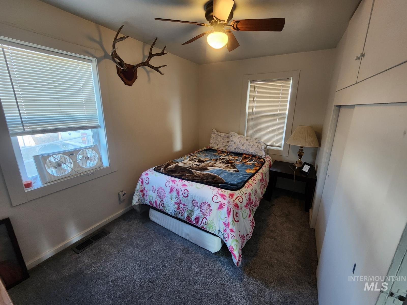514 North 11th Street Nyssa, OR 97913 - Photo 11 of 33 Bedroom featuring dark colored carpet and a ceiling fan
