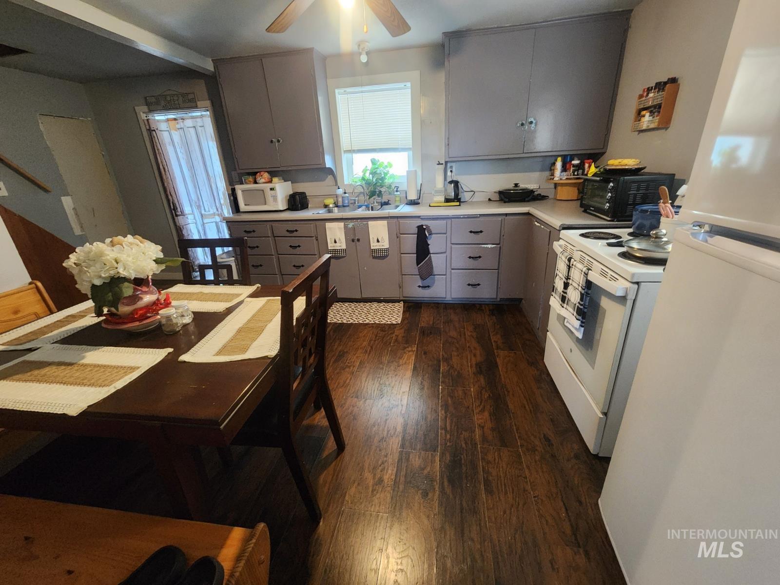 514 North 11th Street Nyssa, OR 97913 - Photo 4 of 33 Kitchen featuring white appliances, light countertops, gray cabinetry, and dark wood-style floors