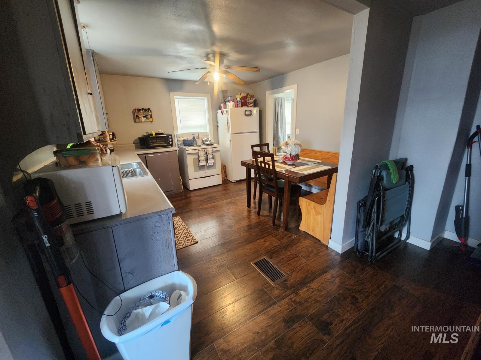 514 North 11th Street Nyssa, OR 97913 - Photo 5 of 33 Kitchen featuring light countertops, white appliances, dark wood finished floors, and a ceiling fan