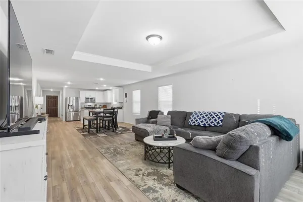 a living room with furniture a dining table and a potted plant