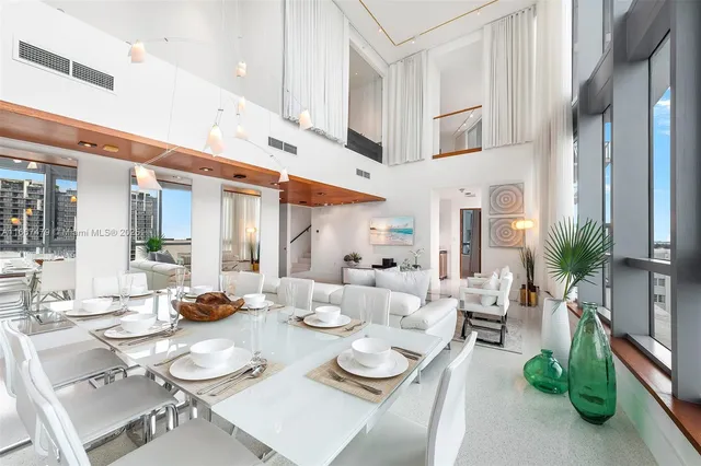 a view of a dining room with furniture a rug and a kitchen view