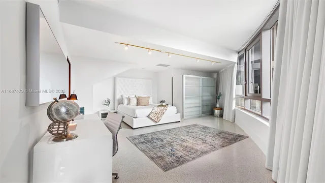 a large bedroom with a bed and a view of living room