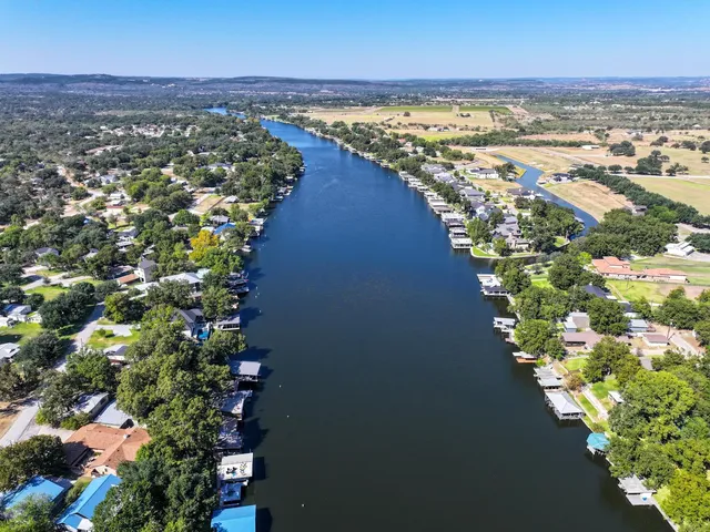 an aerial view of residential houses with outdoor space and trees