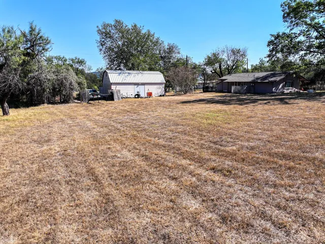 a view of house with yard and trees