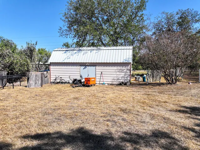 a view of a house with backyard and trees