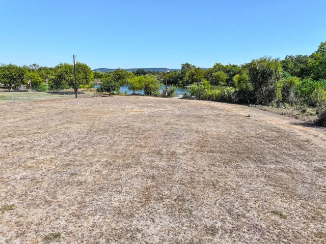 a view of a field with trees in the background