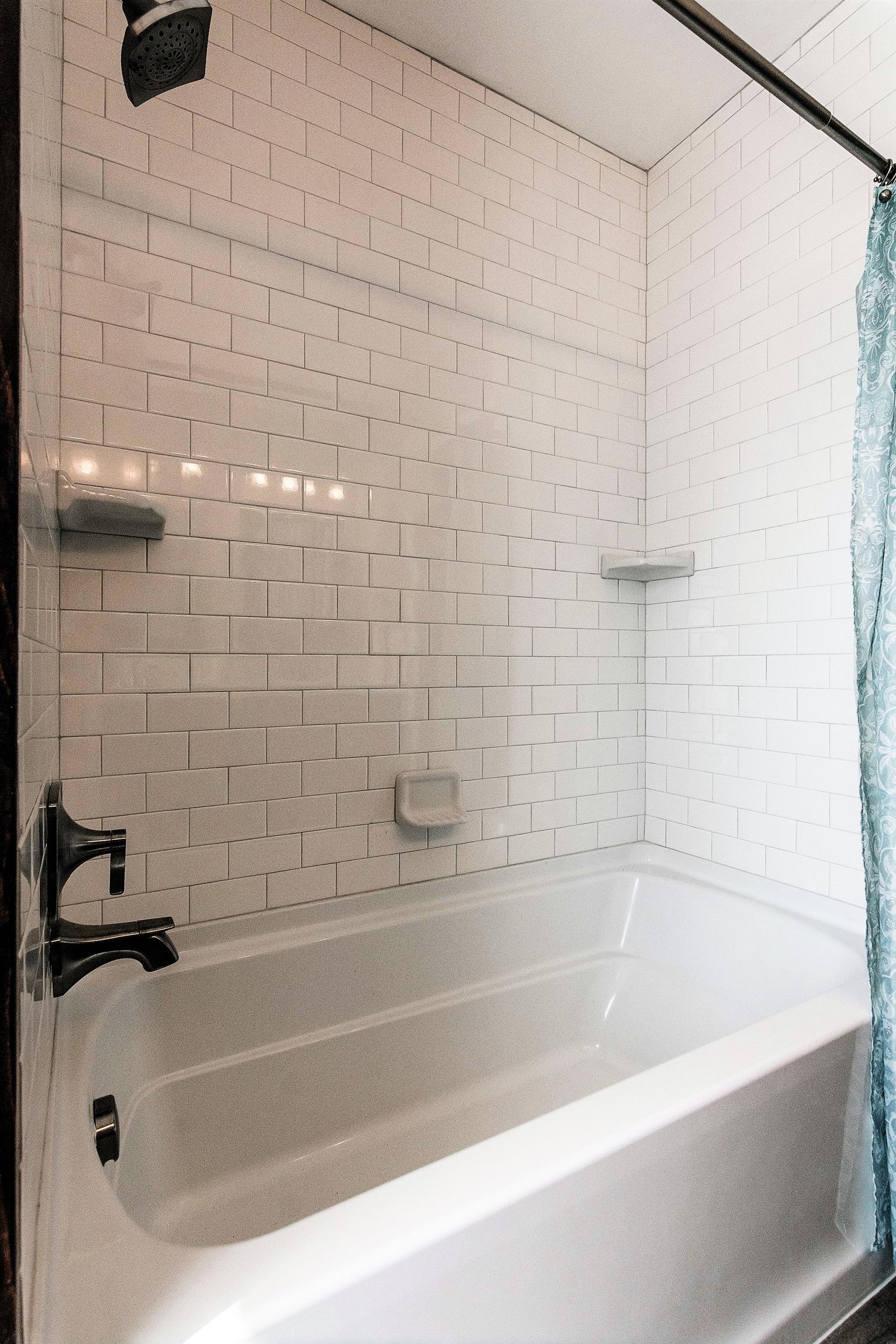 319 Airport Road Portland, TN 37148 - Photo 22 of 29 a white bath tub sitting next to a white sink and a shower