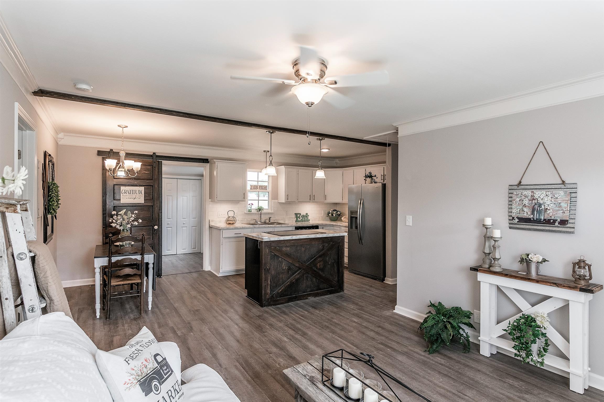 319 Airport Road Portland, TN 37148 - Photo 4 of 29 a kitchen with stainless steel appliances kitchen island granite countertop a refrigerator a stove a sink a dining table and chairs with wooden floor