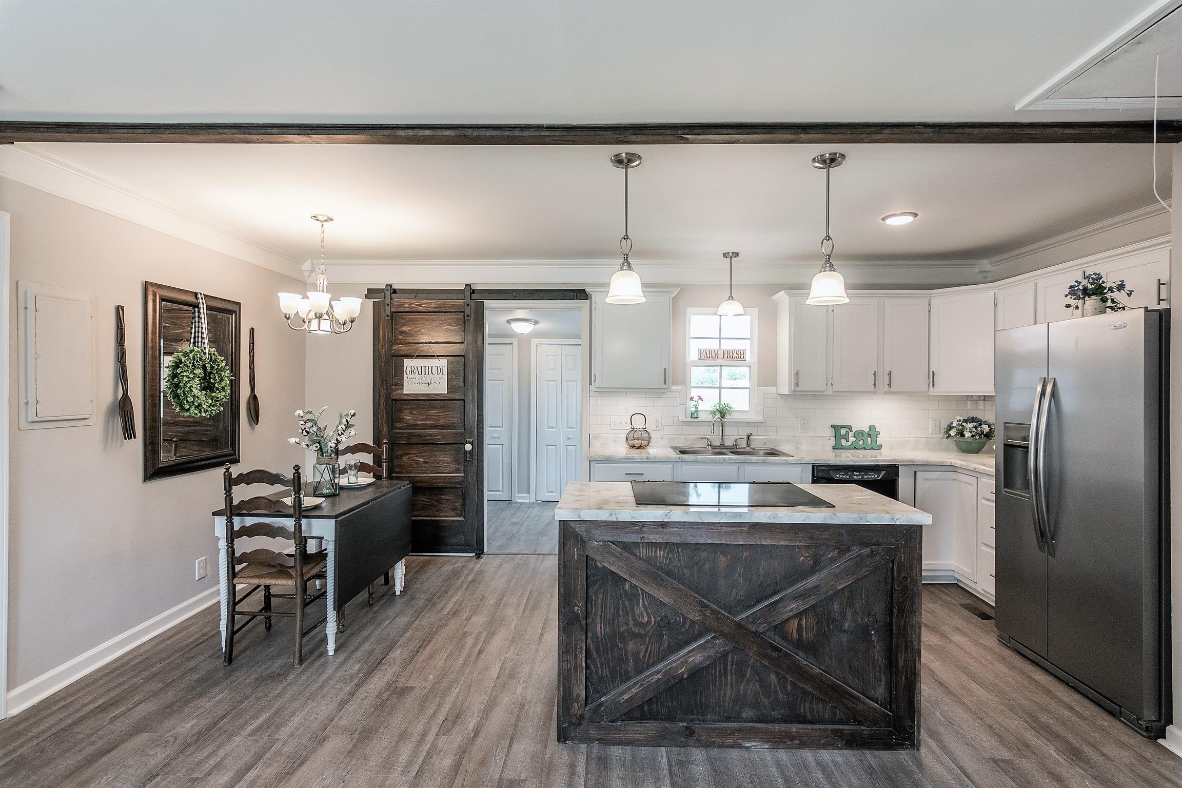 319 Airport Road Portland, TN 37148 - Photo 7 of 29 a kitchen with stainless steel appliances a dining table chairs refrigerator and cabinets