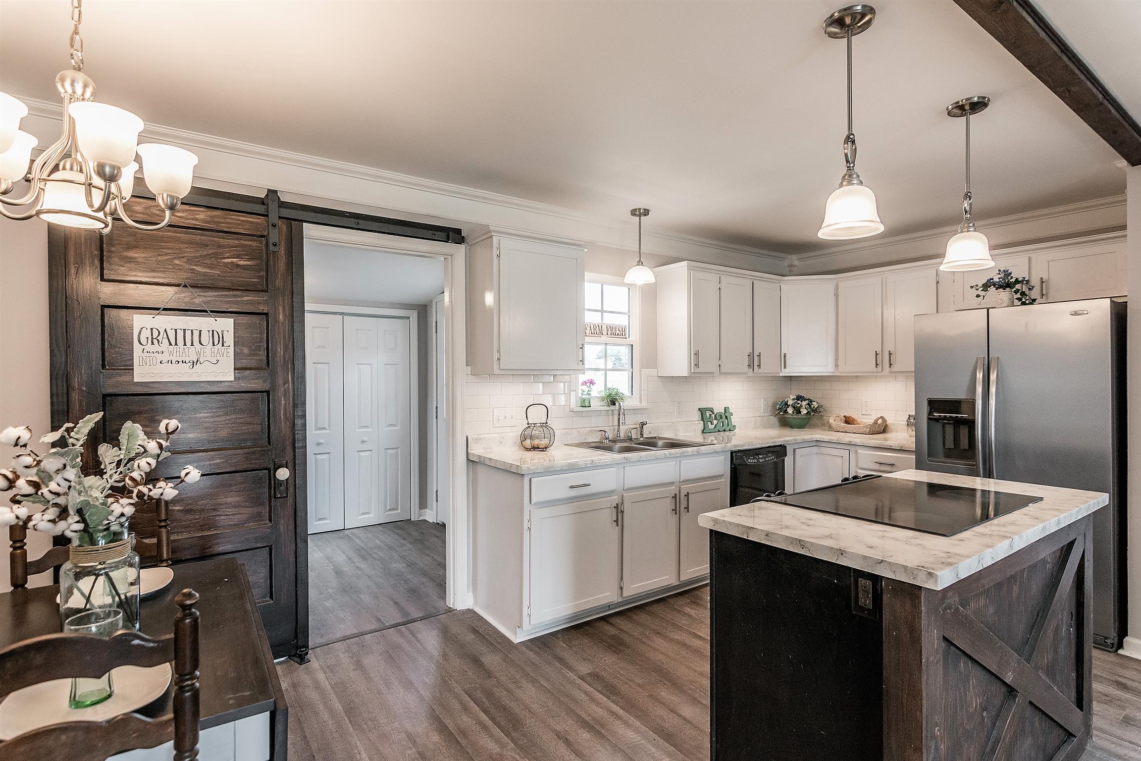 319 Airport Road Portland, TN 37148 - Photo 10 of 29 a kitchen with a center island wooden floor stainless steel appliances and cabinets
