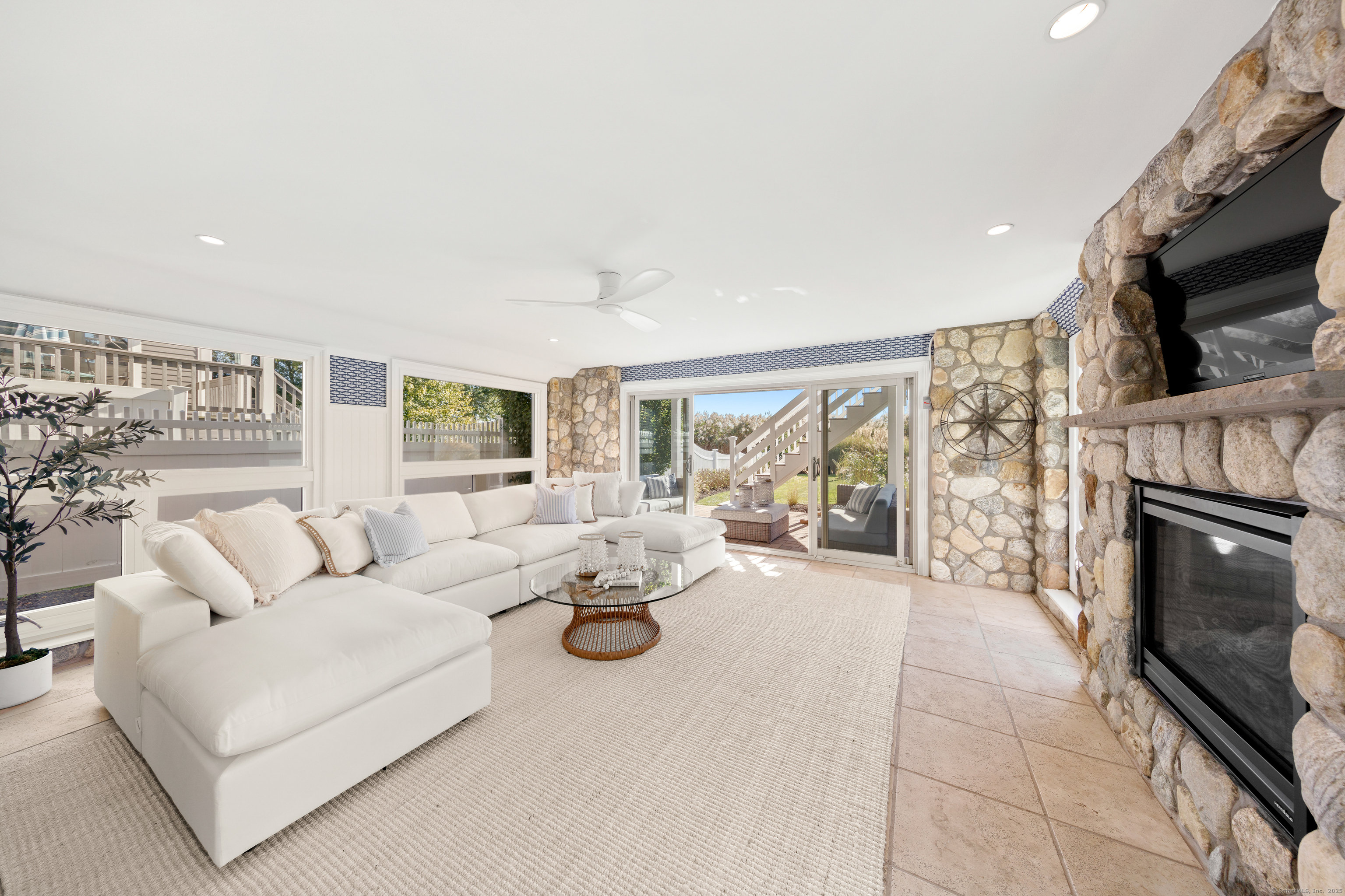 748 Rowland Road Fairfield, CT 06824 - Photo 25 of 38 a living room with furniture a fireplace and a flat screen tv
