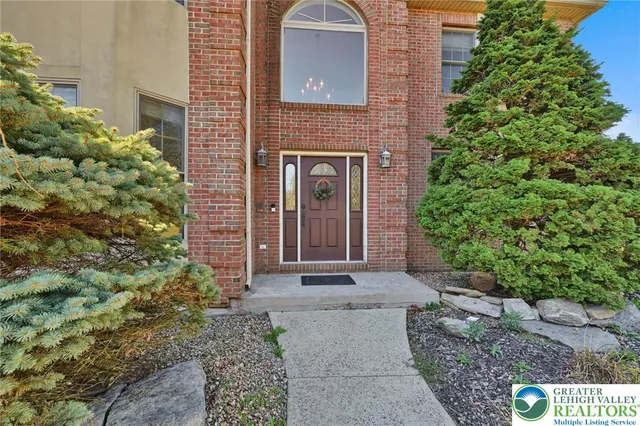 a view of an empty room with wooden floor and windows