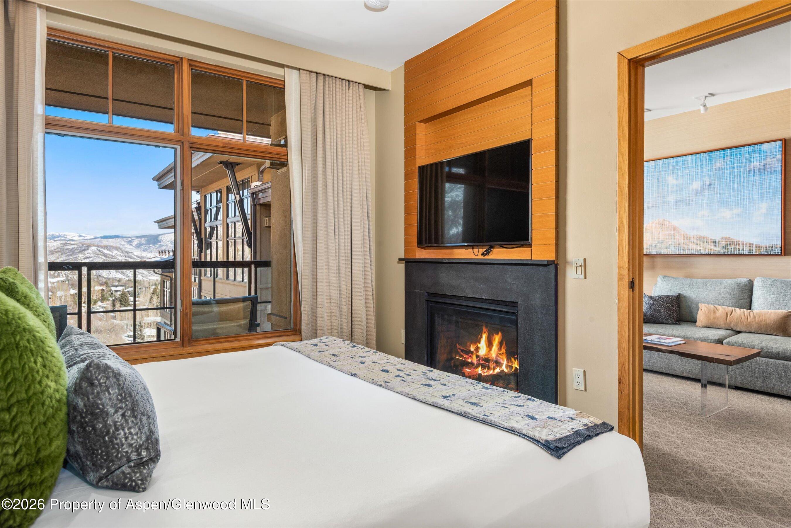 130 Wood Road, Unit 716 Snowmass Village, CO 81615 - Photo 9 of 12 a bedroom with a bed and a fireplace