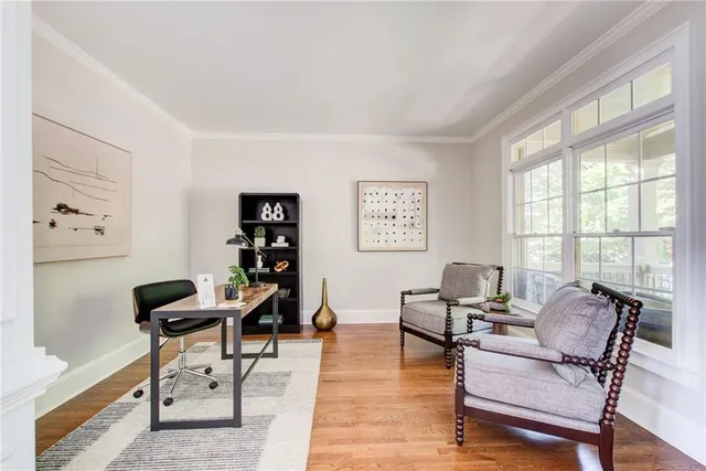 a view of a dining room and livingroom with furniture wooden floor a chandelier