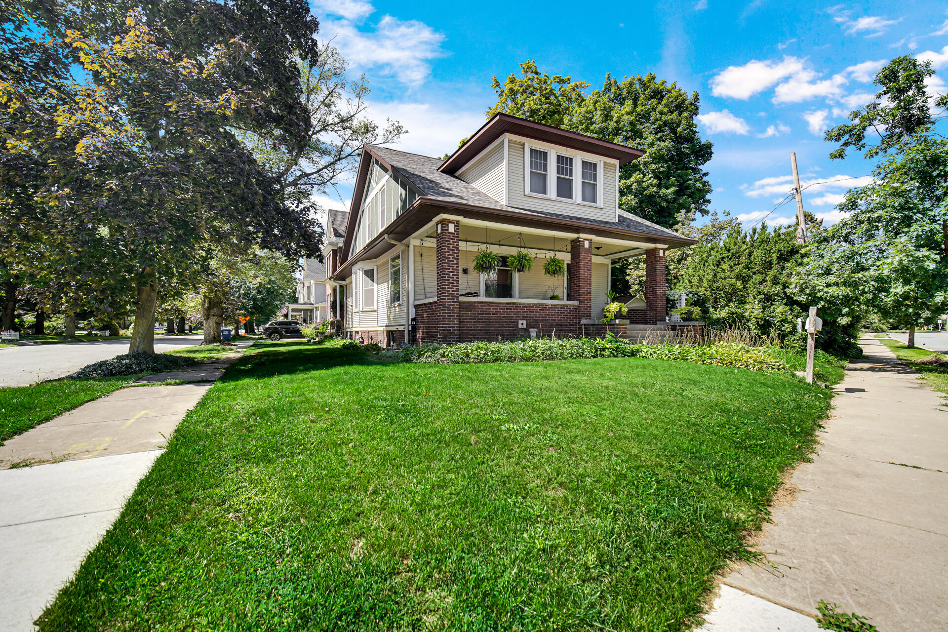 a front view of a house with a garden and trees