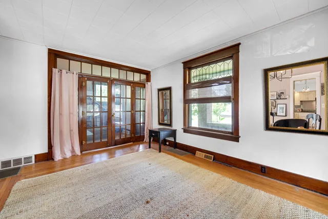 a living room with hardwood floor and large window