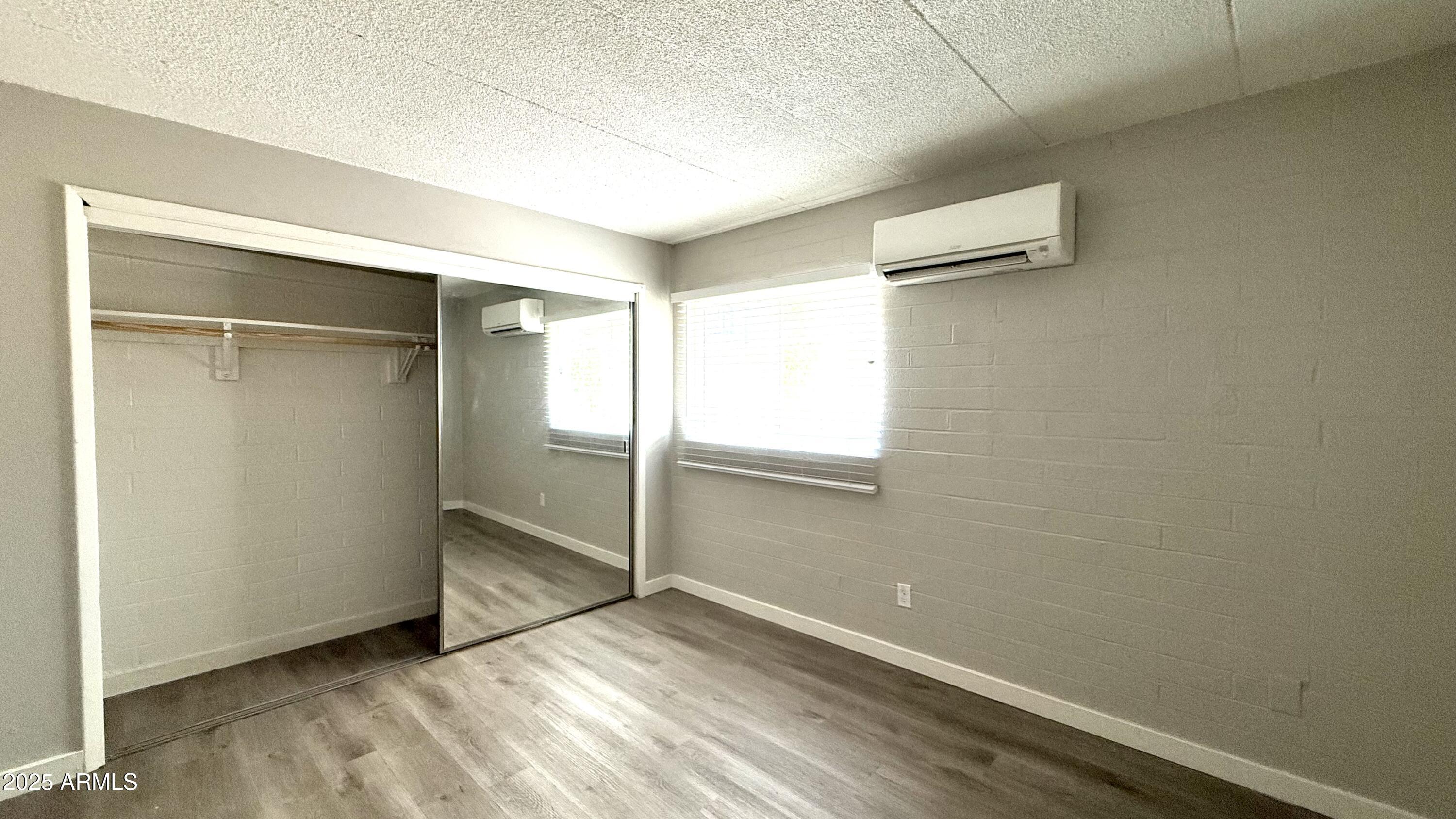 44 East Roanoke Avenue, Unit 4 Phoenix, AZ 85012 - Photo 19 of 19 a view of an empty room with wooden floor and a window