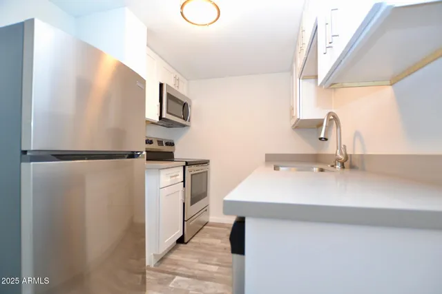 a kitchen with a sink stainless steel appliances and cabinets
