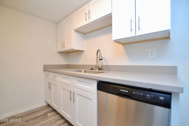 a kitchen with stainless steel appliances a sink dishwasher and cabinets